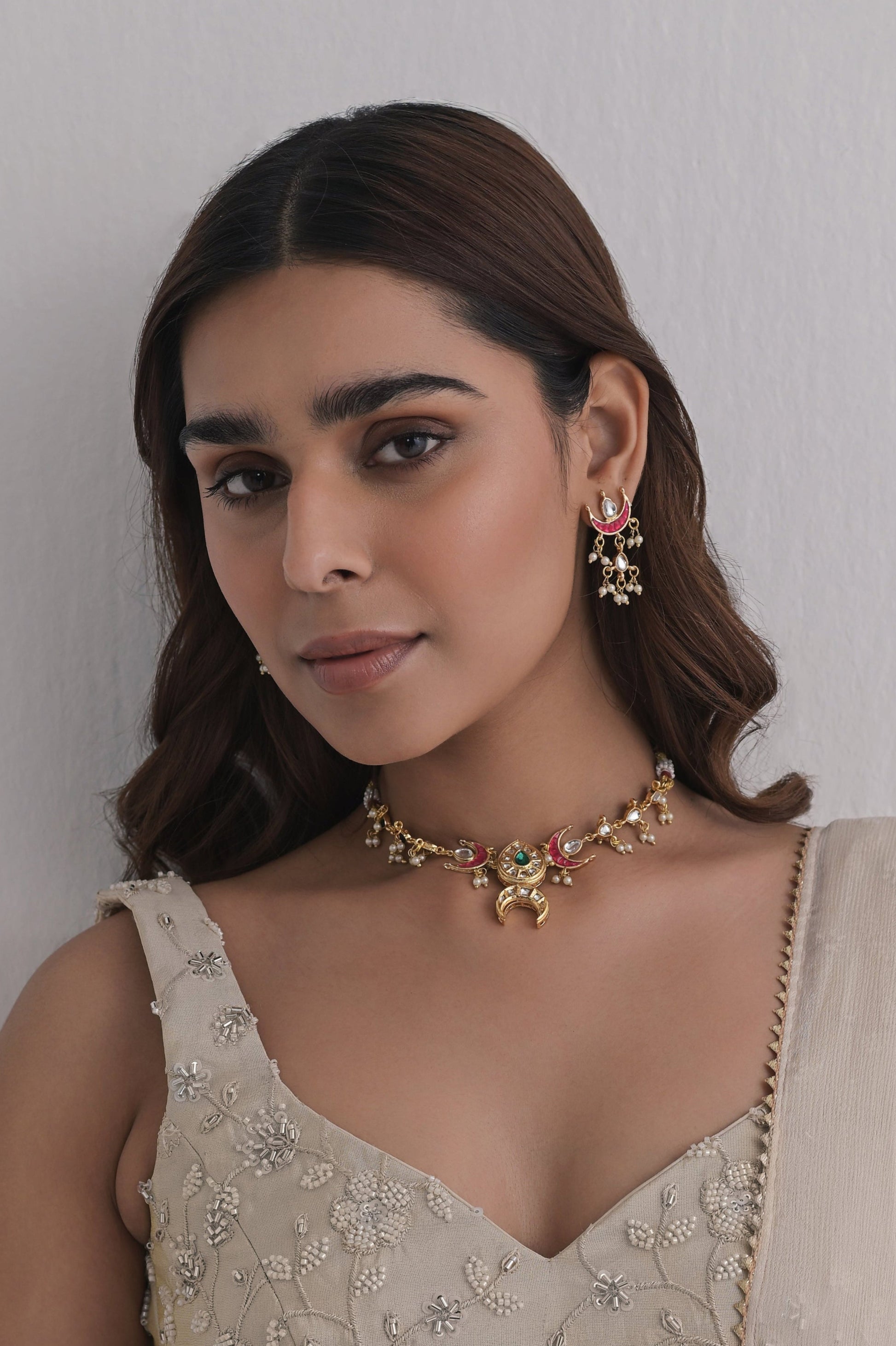 Jewelry set featuring gold-finished brass, vibrant pink enamel, and kundan work. Includes necklace and earrings.